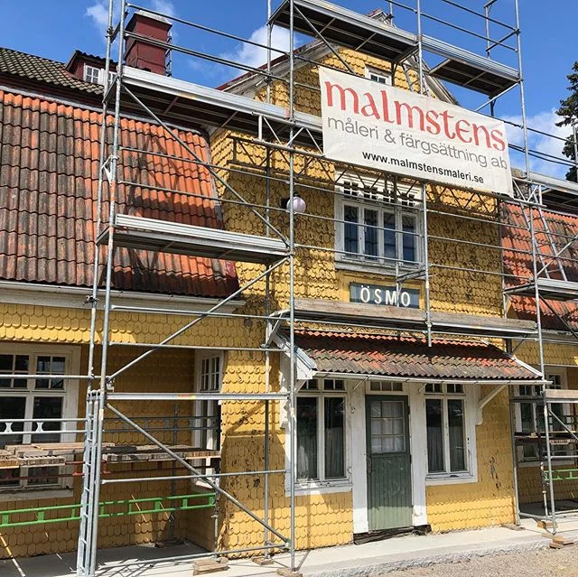 Ösmo stationshus med byggnadsställning runt fasaden under utvändig renovering